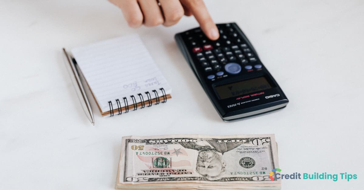 person using calculator with cash and notebook to catch up on credit card debt