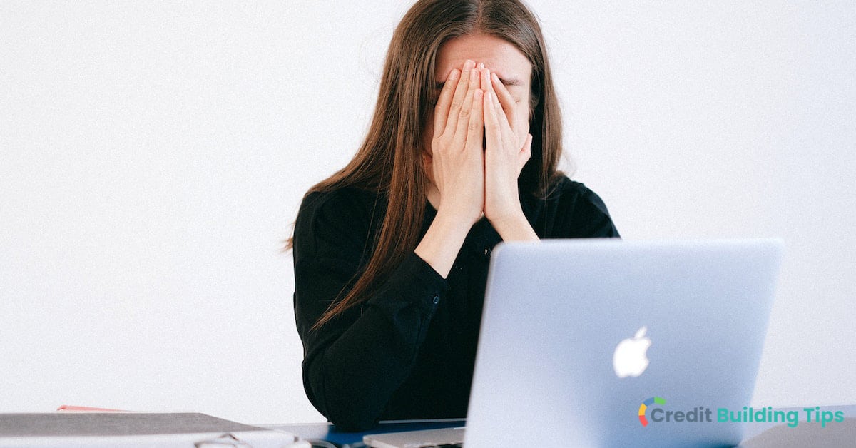 woman stressed at computer because of missed credit card payments