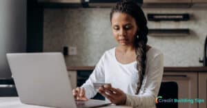 woman looking at credit card that has new updated tradeline on credit report